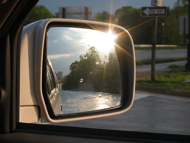 Sunset in rearview mirror after rainstorm
